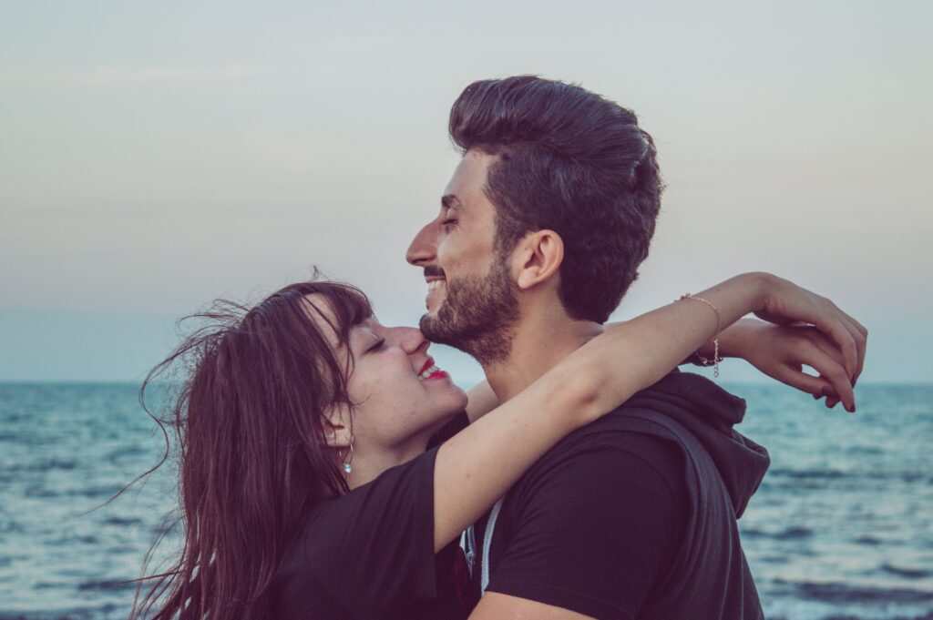 coppia al mare che sorride felice e serena