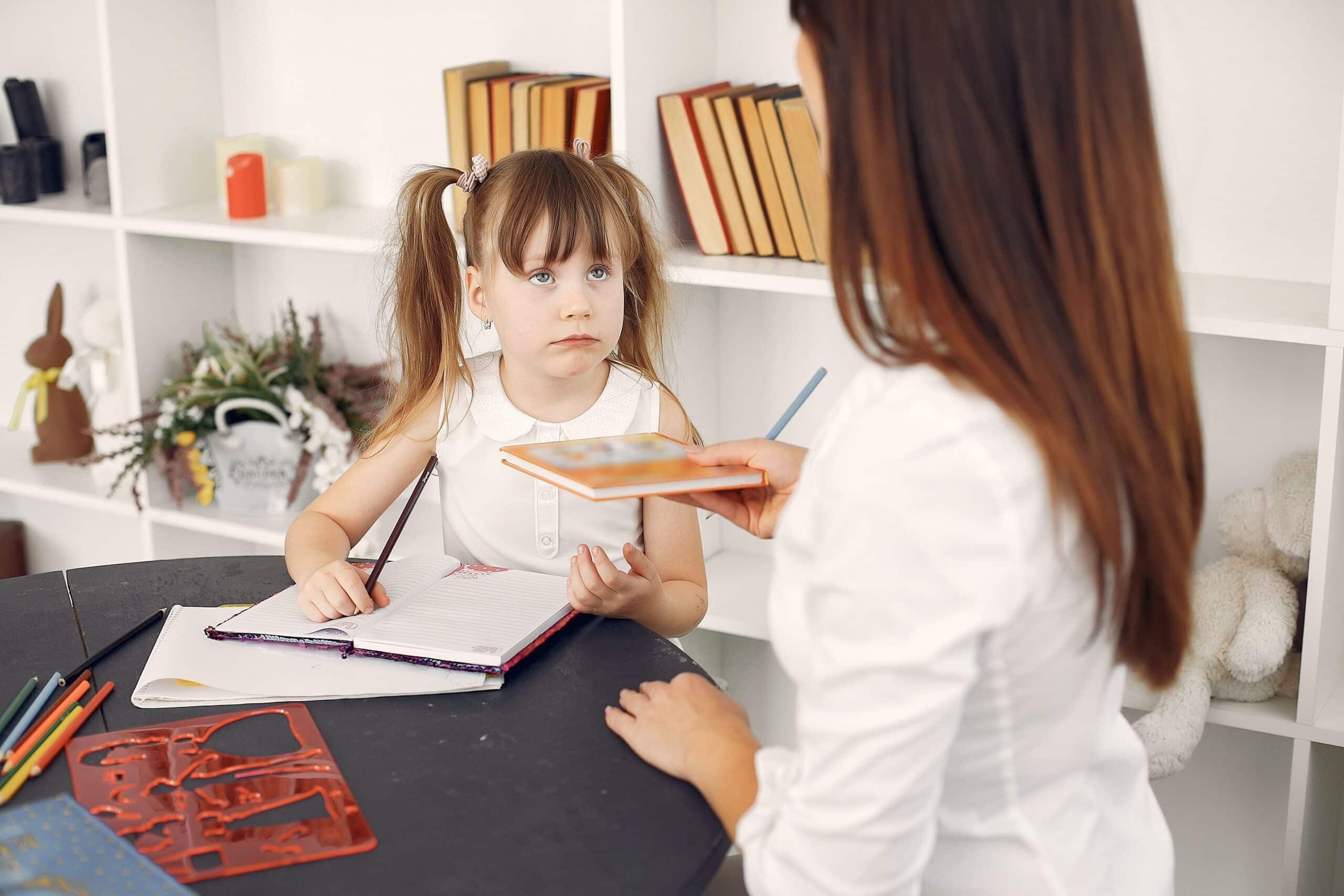 bambina con aria confusa che guarda la maestra